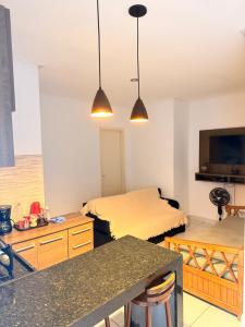 a room with a bed and a kitchen with two lights at RESIDENCIAL SOPHIA in Eunápolis