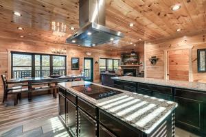 a kitchen with wooden walls and a wooden ceiling at Massive Cabin Indoor Pool Driving Simulators Sleeps 20 in Gatlinburg