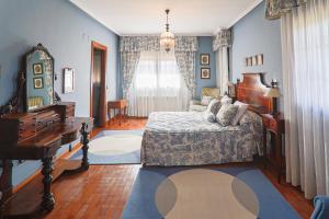 a bedroom with blue walls and a bed and a piano at Montesión 71 - Casa con piscina & jardín, al lado de Puy du Fou in Toledo +64 photos
