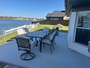 a table and chairs on a patio next to the water at Lake Granbury Retreat in Granbury