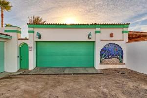 a garage with a green garage door in front of a house at Comfortable Beachfront Condo Las Olas II 1 in Puerto Peñasco