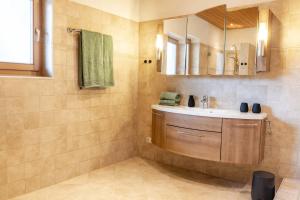 a bathroom with a sink and a mirror at Alps Living Söll in Söll +21 photos