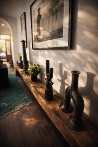 a long wooden shelf with vases on a wall at Loft incroyable en médina in Essaouira +22 photos