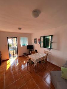 a living room with a table and chairs and a couch at Robinzonska kuća uz more in Tkon