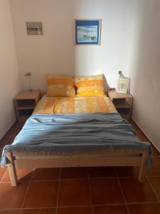 a bed in a room with two night stands at Robinzonska kuća uz more in Tkon