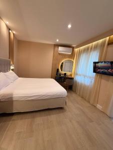 a bedroom with a bed and a flat screen tv at Windofsand Room in Cagliari