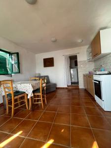 a kitchen and living room with a table and chairs at Robinzonska kuća uz more in Tkon +18 photos