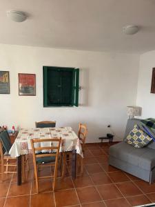a dining room with a table and a couch at Robinzonska kuća uz more in Tkon