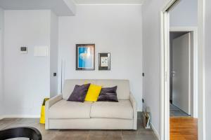 a white couch with two yellow pillows in a living room at Suite Andrea-Luxury Central Suite in Bergamo
