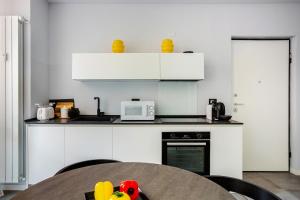 a kitchen with white cabinets and a table with toys at Suite Andrea-Luxury Central Suite in Bergamo