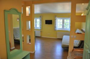 ヤストシェンビャ・グラにあるWilla Mariaの黄色い壁の部屋と鏡のあるリビングルーム