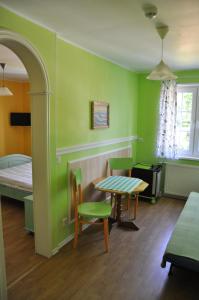 ヤストシェンビャ・グラにあるWilla Mariaの緑の壁の客室で、テーブルとベッドが備わります。
