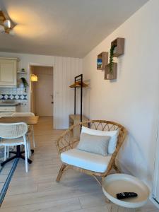 a living room with a rattan chair and a table at Studio Ti’Sable 50m de la plage in Fort-Mahon-Plage +5 photos