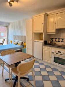 a kitchen with a table and chairs in a room at Studio Ti’Sable 50m de la plage in Fort-Mahon-Plage