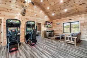 a room with two arcade machines in a cabin at Massive Cabin Indoor Pool Driving Simulators Sleeps 20 in Gatlinburg