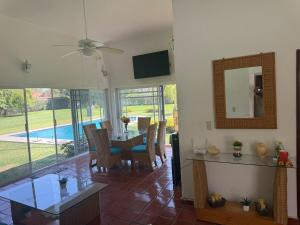 a dining room with a table and a mirror at Casa Los Cardenales Ticuman in Ticumán