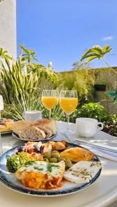 a table with plates of food and glasses of wine at מלון אבא תל-אביב-יפו in Tel Aviv