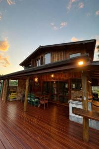 a house with a deck with a kitchen and a table at Refugio da Serra - Cachoeira dos Bufalos in Pindamonhangaba