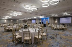 a banquet hall with tables and chairs and a screen at DoubleTree by Hilton West Edmonton in Edmonton