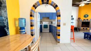 a kitchen with a table and a kitchen with blue cabinets at Cozy & Colorful Beachfront Condo Las Olas II 4 in Puerto Peñasco