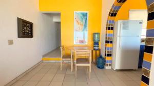 a dining room with a table and a refrigerator at Cozy & Colorful Beachfront Condo Las Olas II 4 in Puerto Peñasco +19 photos