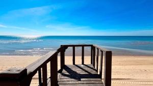 a wooden boardwalk leading to the ocean on a beach at Charming 3-Bedroom Beachfront Home Bahia Delfin in Las Conchas +29 photos