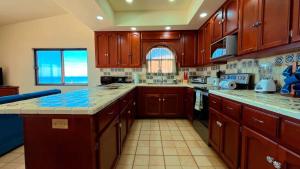 a kitchen with wooden cabinets and a counter top at Charming 3-Bedroom Beachfront Home Bahia Delfin in Las Conchas