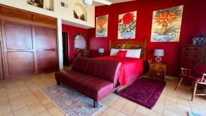 a red bedroom with a bed and a couch at Charming 3-Bedroom Beachfront Home Bahia Delfin in Las Conchas