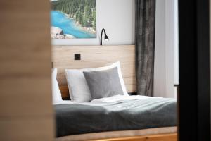 a bedroom with a bed with a picture on the wall at Moderne Wohnung mit einer wunderschönen Aussicht in der Residenz Silvretta, inkl Silvretta Card Premium in See