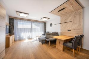 a dining room with a wooden table and chairs at Moderne Wohnung mit einer wunderschönen Aussicht in der Residenz Silvretta, inkl Silvretta Card Premium in See