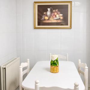 a white table with a picture of fruit on the wall at Holibai Amieiro Apto amplio y luminoso cerca de la playa, Baiona in Baiona