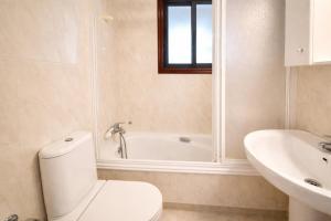 a bathroom with a toilet and a tub and a sink at Holibai Amieiro Apto amplio y luminoso cerca de la playa, Baiona in Baiona