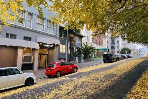 ein rotes Auto, das am Straßenrand geparkt ist in der Unterkunft Gamma Hotel in Auckland