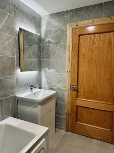 a bathroom with a sink and a wooden door at Ocean view apartment in Tralee