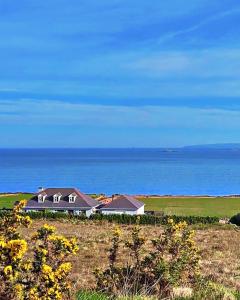 a house on a hill with the ocean in the background at Ocean view apartment in Tralee