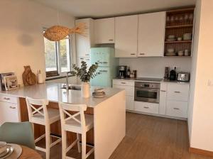 a kitchen with white cabinets and a table with chairs at Pico Island Villas 38 - Private Atlantic Retreat in Santo António