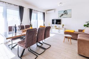 a dining room and living room with a table and chairs at Apartment Petar in Kaštela