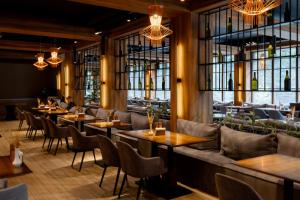 a restaurant with tables and chairs and windows at Wood Hotel Resort & SPA in Bukovel