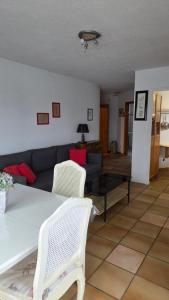 a living room with a couch and a table and chairs at Moléson Altitude in Moleson