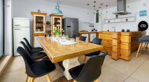 a kitchen with a wooden table and black chairs at Willa Bosmański Zakątek in Tałty
