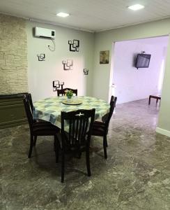 a dining room with a table and chairs and a tv at Casa Ruta 3 Río Gallegos in Río Gallegos