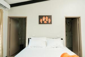 a bedroom with a white bed and two doors at Raluve BnB in Rakiraki
