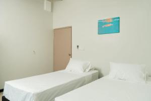 two beds sitting next to each other in a room at Raluve BnB in Rakiraki