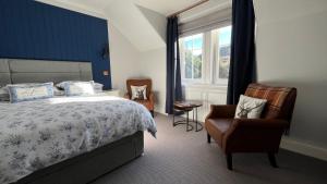 a bedroom with a bed and a chair and a window at Lochinver Manse in Lochinver