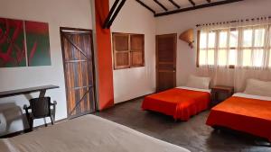 a room with two beds and a table and a desk at finca hotel palmas frente a panaca in Quimbaya
