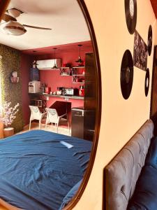a mirror reflecting a room with a bed and a kitchen at Retro Flat in Caruaru