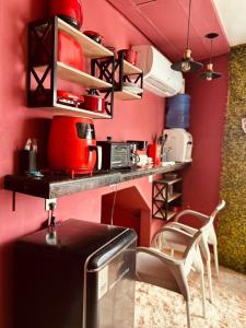 a kitchen with red walls and a counter with a stove at Retro Flat in Caruaru +20 photos