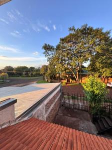 a brick walkway with a fence and a tree at Raíces Vivas Selva Misionera in Oberá