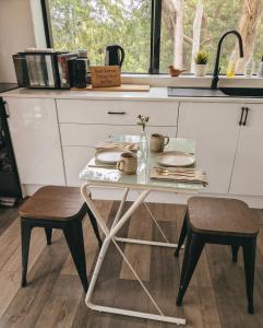 a table in a kitchen with a table and two stools at Beautiful Bush & Yoga Retreat Guest Favourite 6 Stars in Engadine
