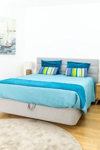 a bed with blue sheets and pillows in a room at Sesimbra Ocean Terrace in Sesimbra +25 photos